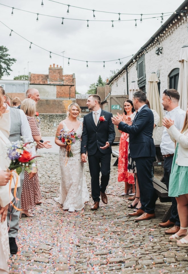 Rosie and Kyle walking together after their wedding in a celebratory way