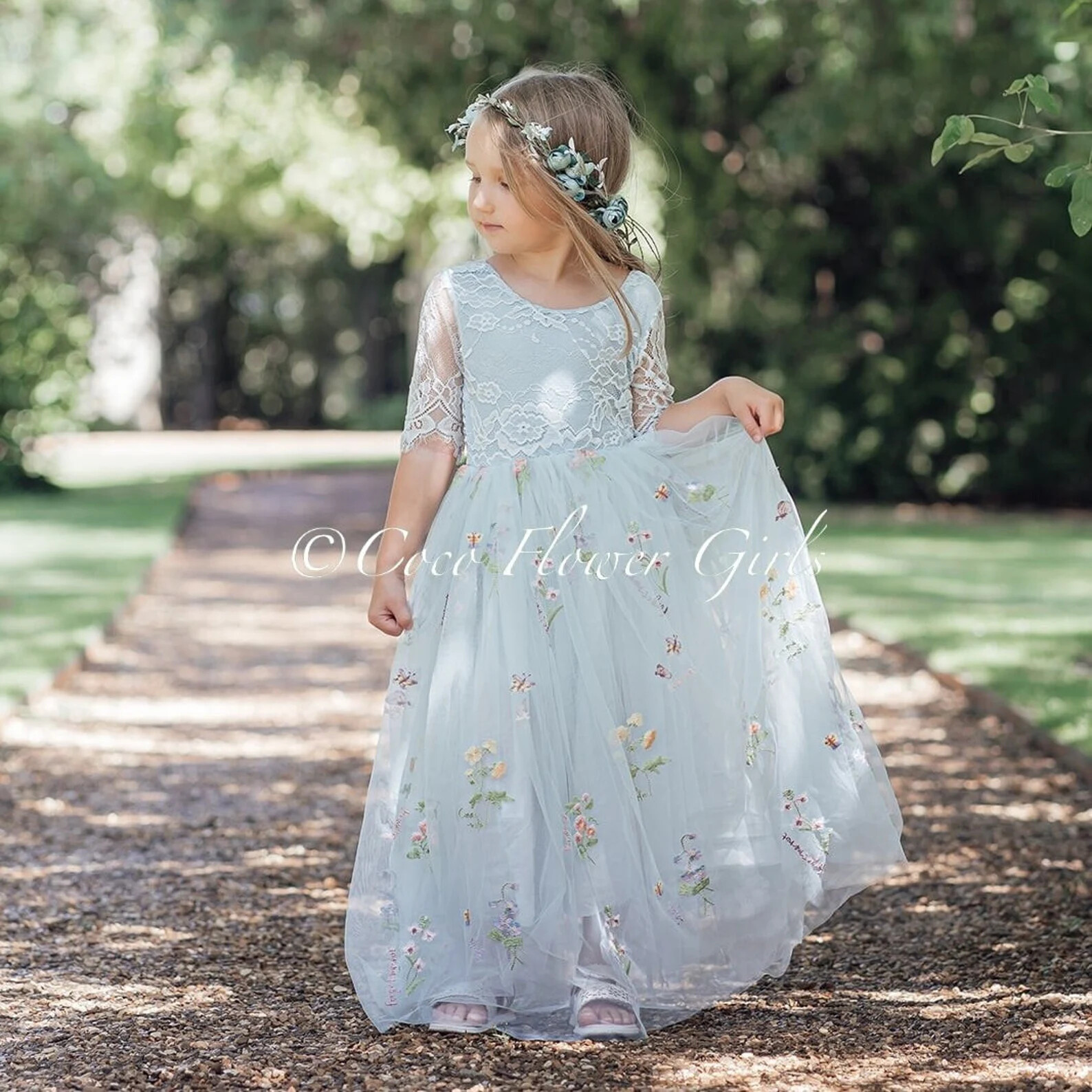 little girl wearing a silver flower girl dress for autumn wedding 