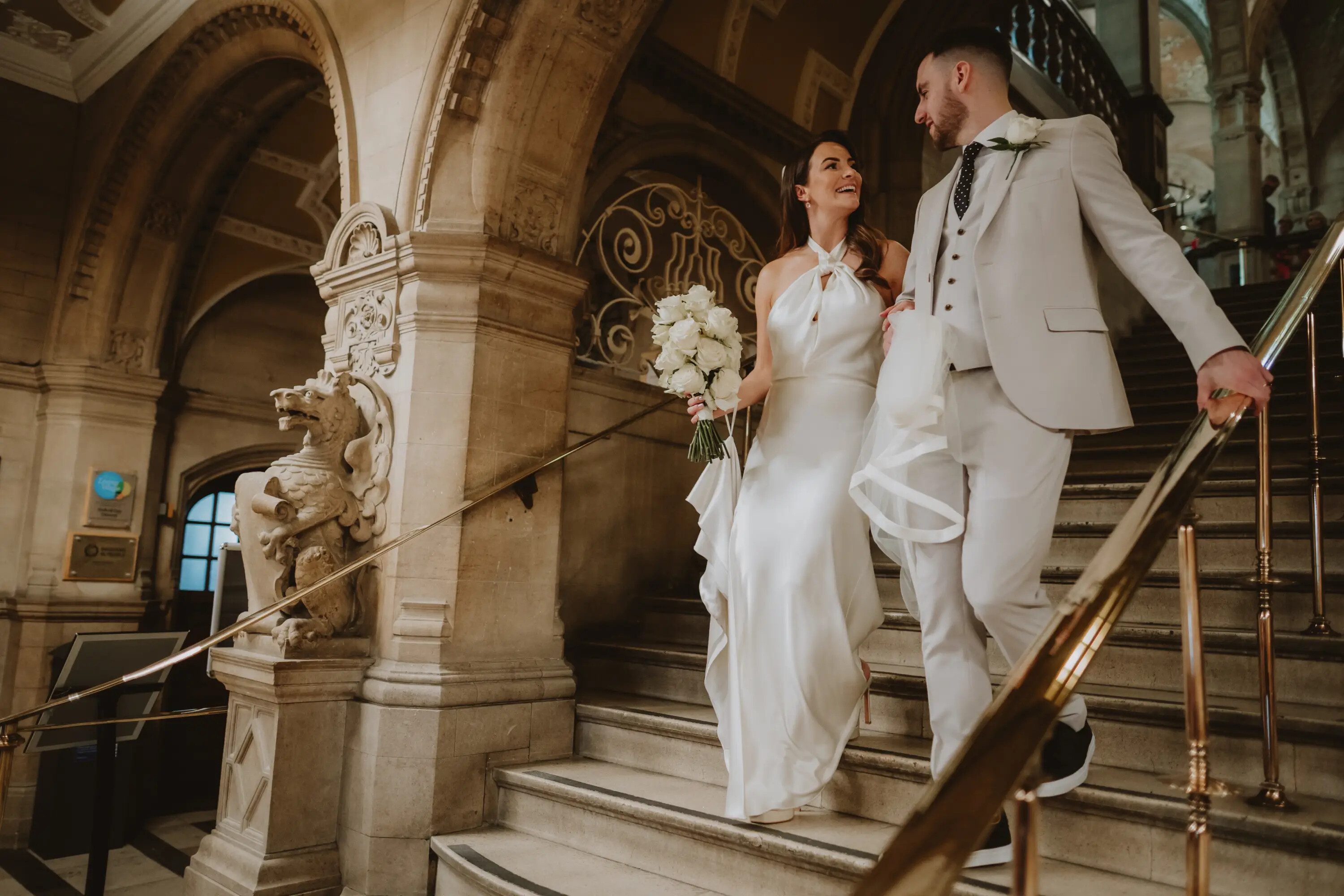 Bride and groom walking down the steps at Oxford Town Hall