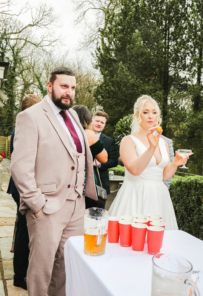 Bride playing beer pong at Mitton Hall wedding