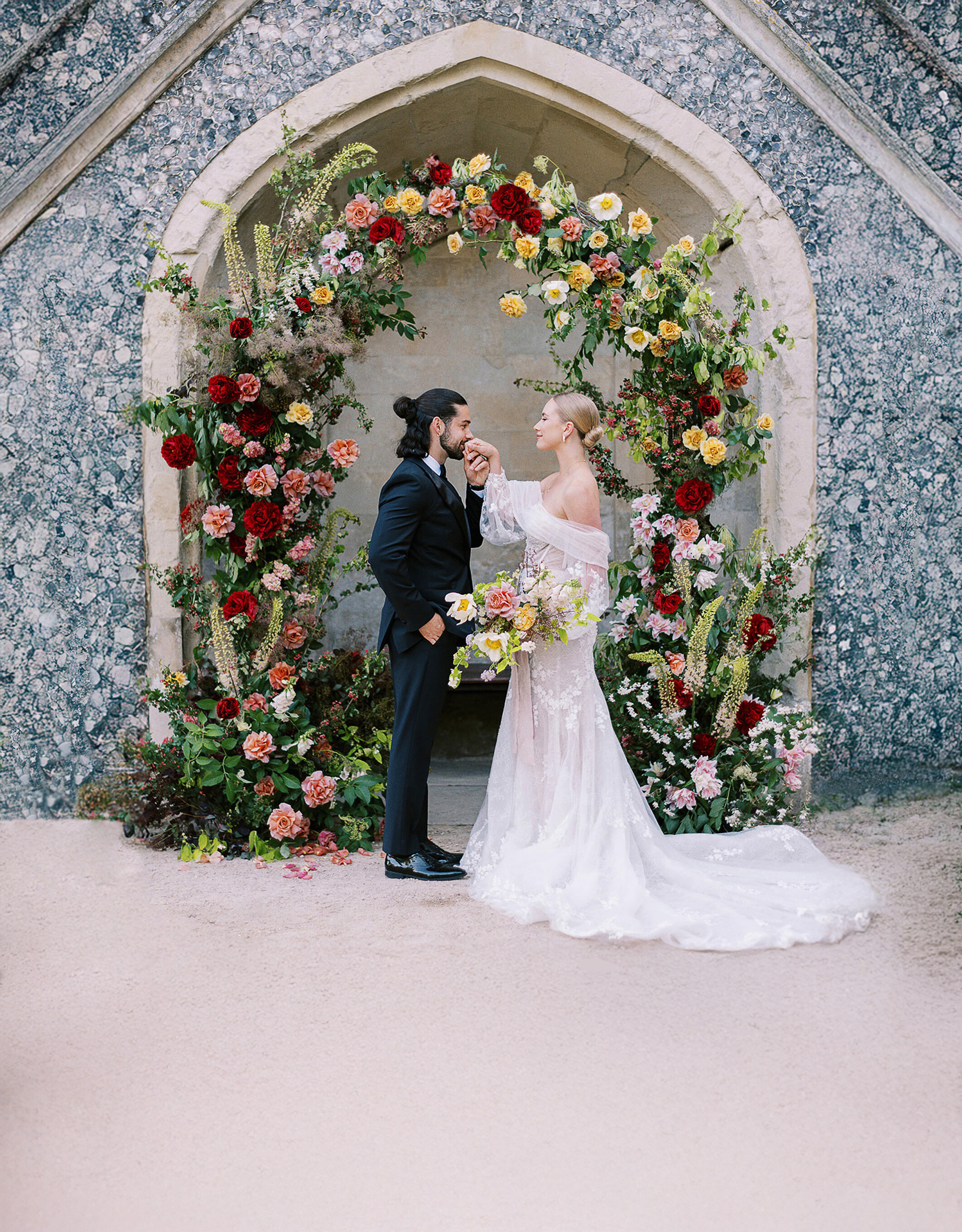 Couple portrait beneath a floral arch at Duke’s Yard at Ashridge House wedding venue