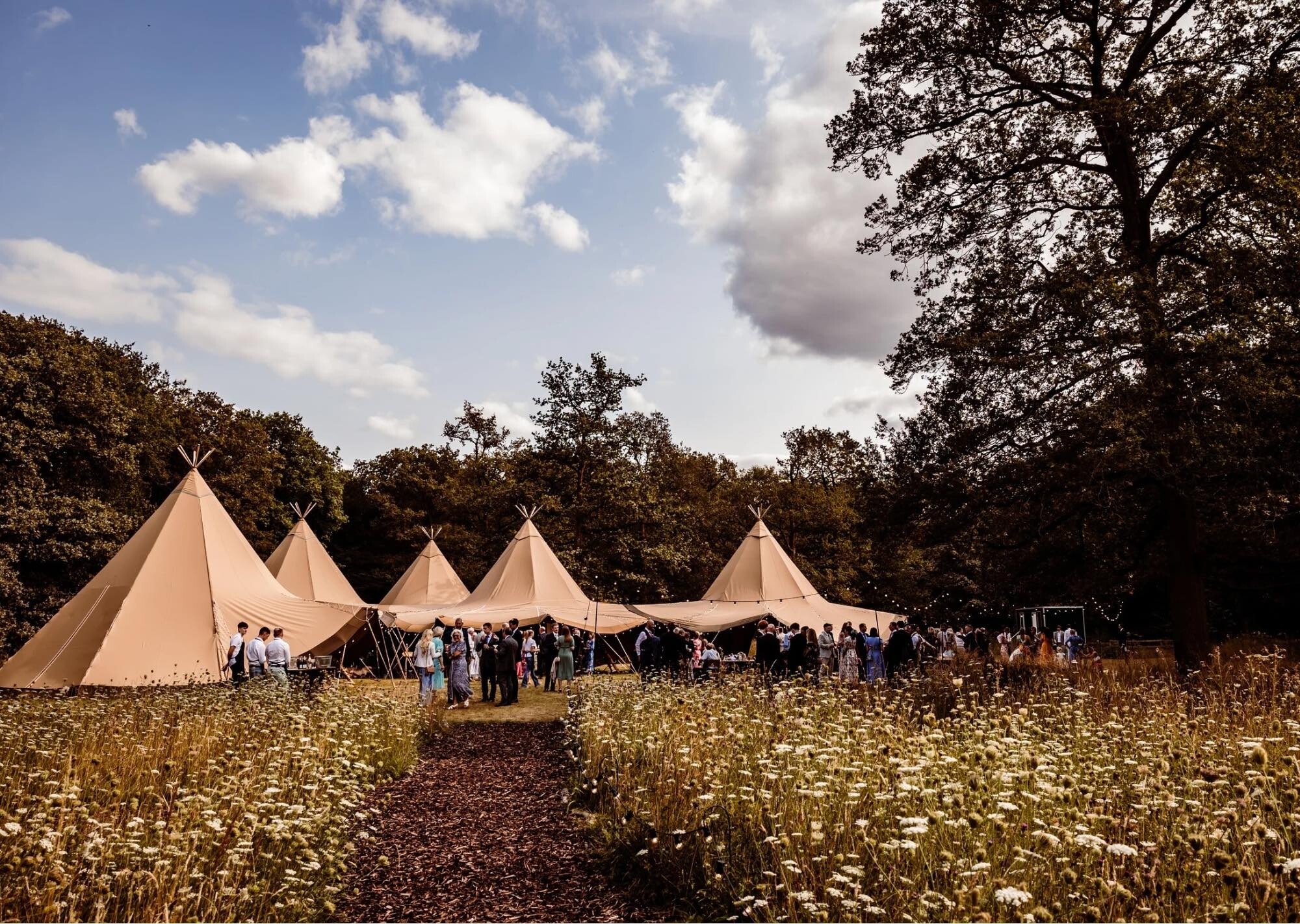Dibbens Wood tipi with wedding guests mingling outside