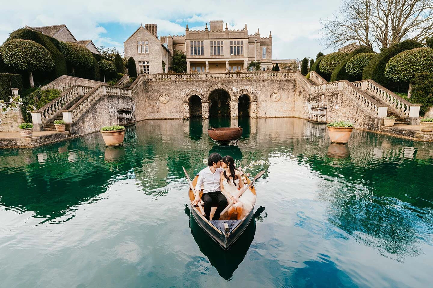 Wedding couple in a boat in the lake at Euridge Manor wedding venue, captured by Indigo Images, Hertfordshire