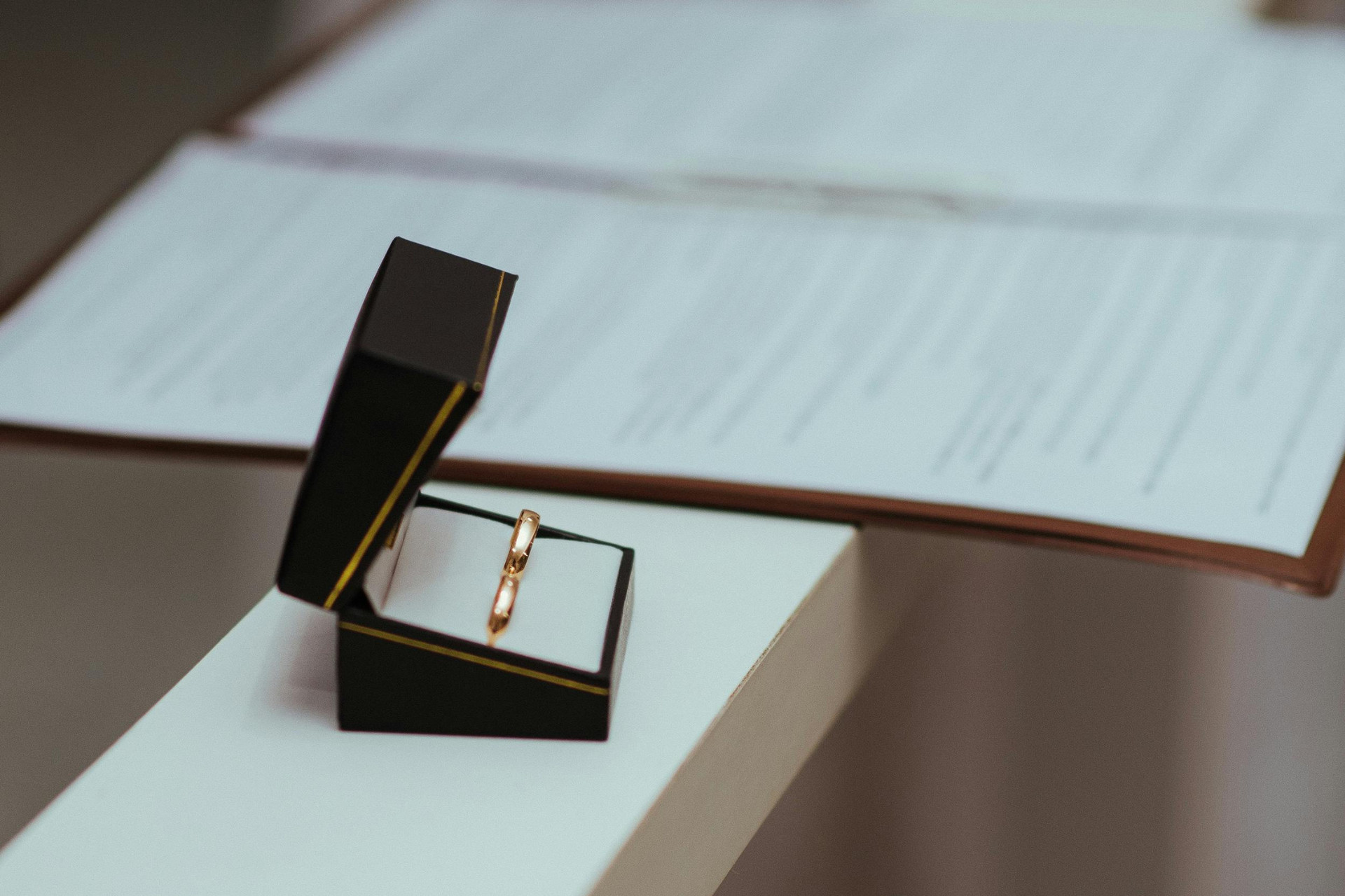 Wedding rings pictured next to important wedding realted documents
