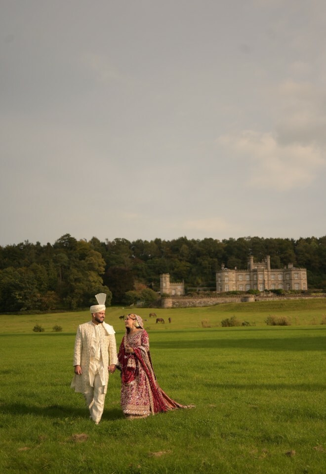 Bride and groom posing with the castle as the backdrop