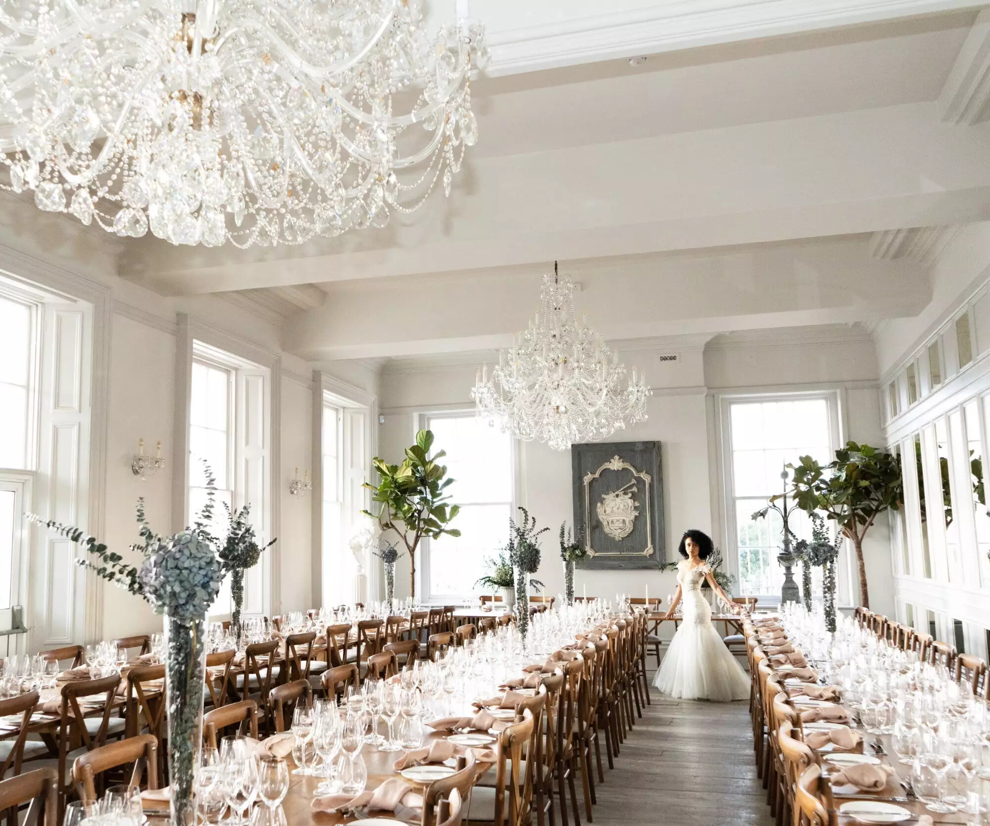 Bride stands between long tables set for a wedding. Inside the Bugle in Hampshire