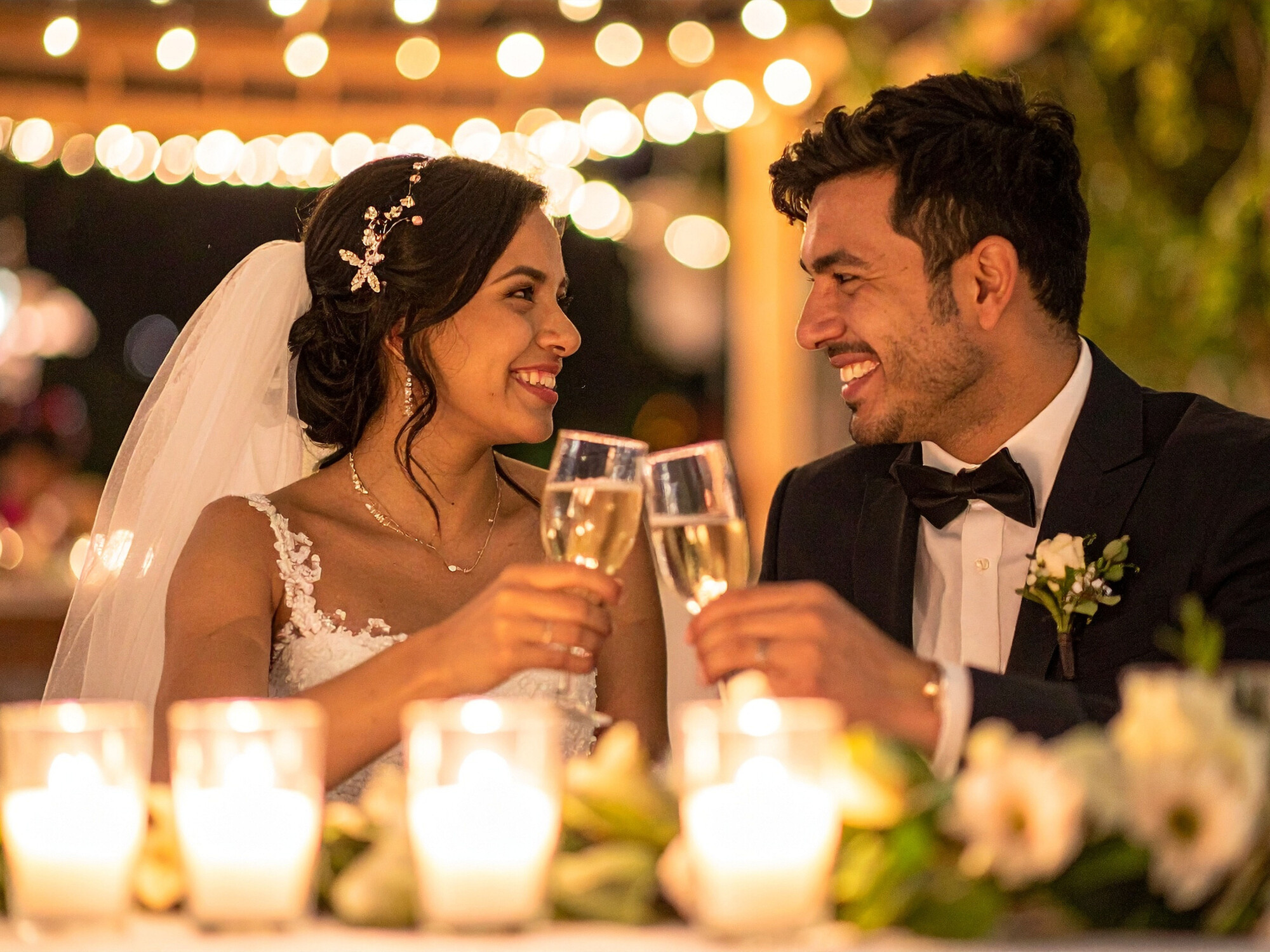 Bride and groom clink glasses on their wedding day