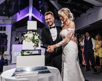 Melissa and James Bunn cutting the cake at their wedding at Swynford Manor