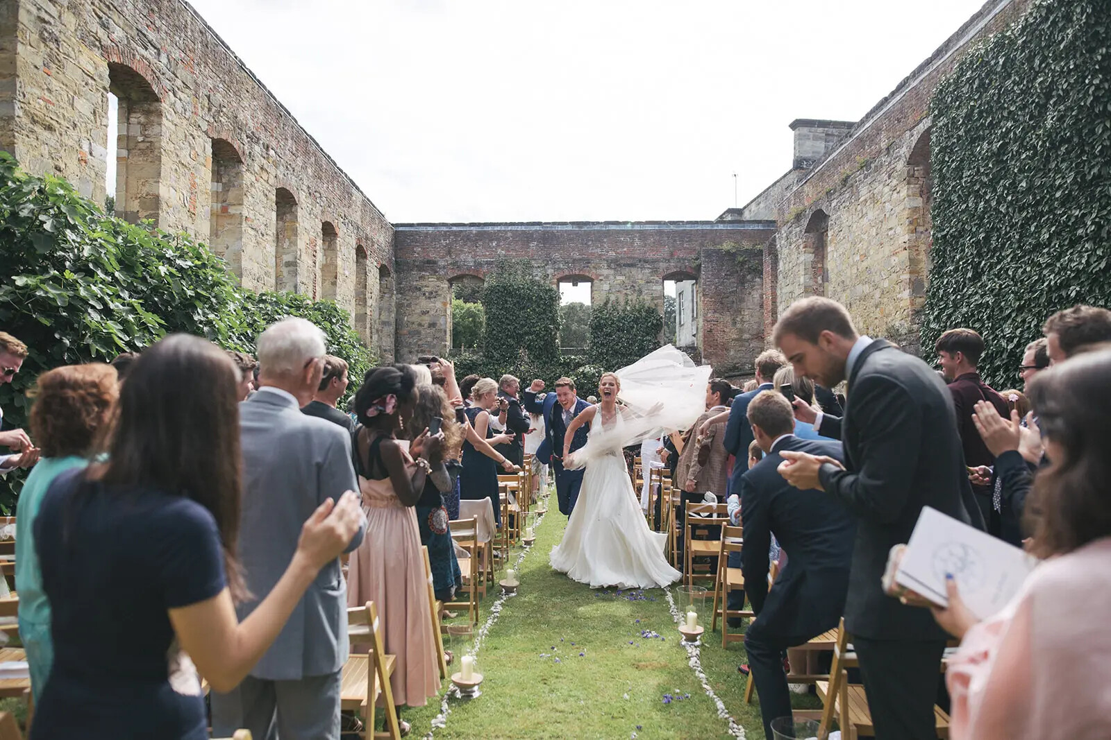 Outdoor wedding ceremony with couple walking down aisle at Newburgh Priory wedding venue in North Yorkshire.