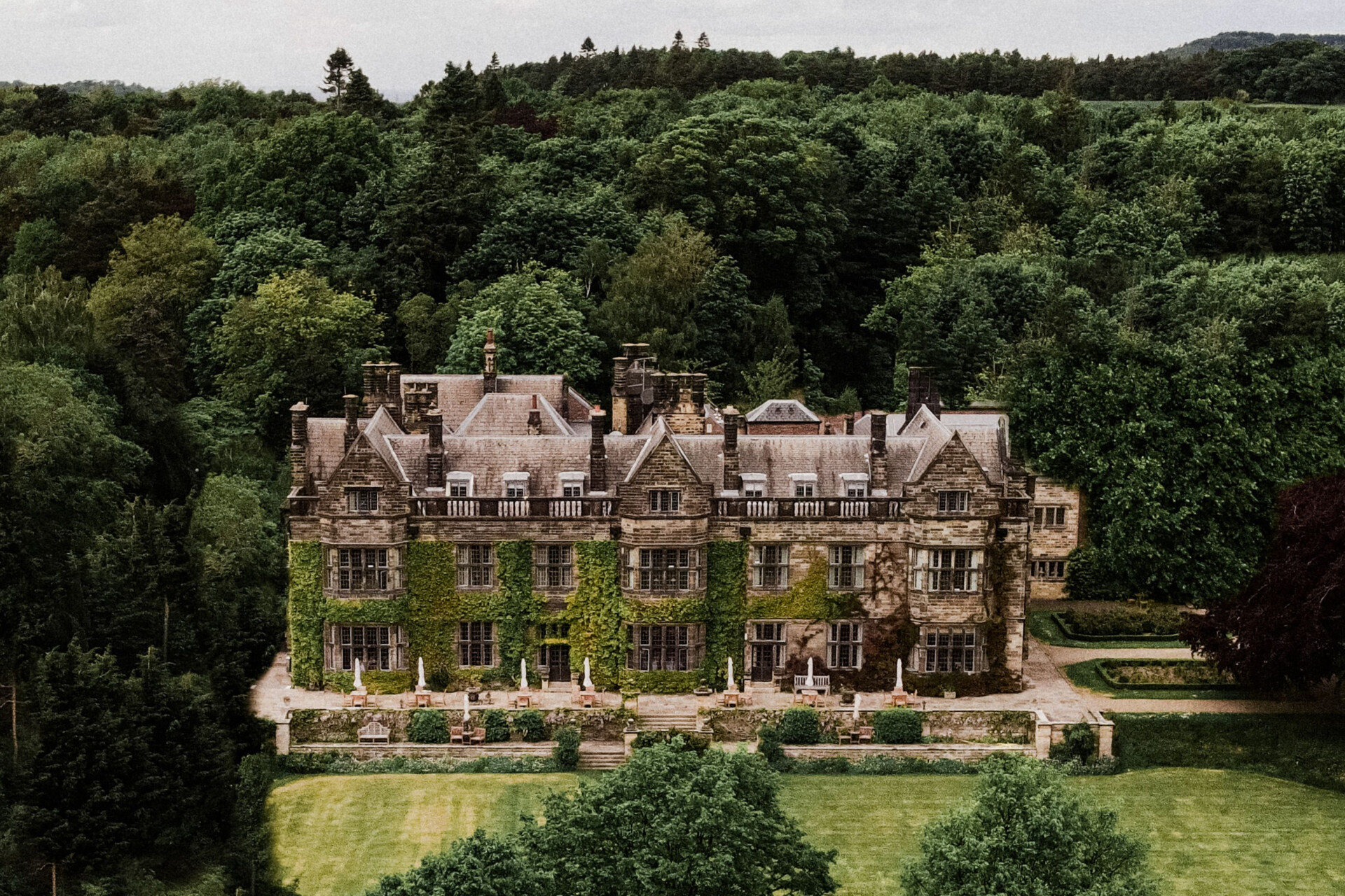 Historic country house wedding venue surrounded by woodland and landscaped gardens.