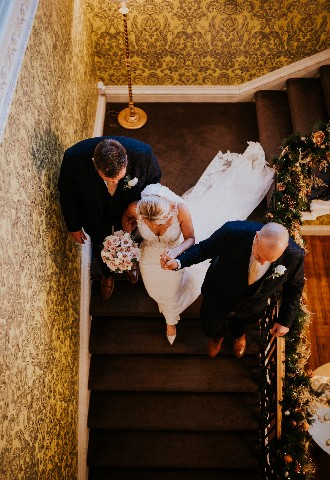 Bride and groomsmen walking down stairs at Hedsor House Buckinghamshire