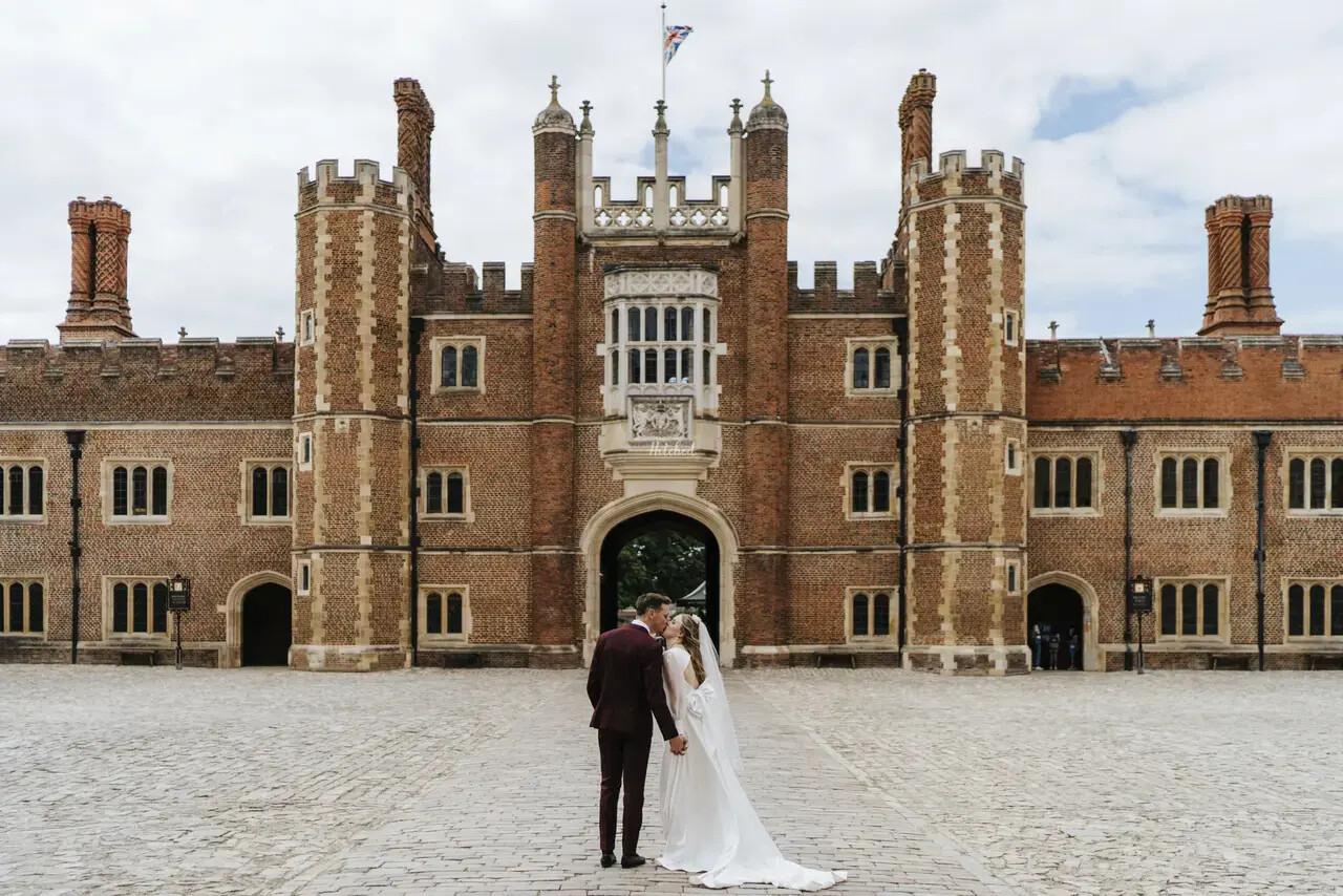 Bride and groom kiss in the courtyard of Hampton Court Palace