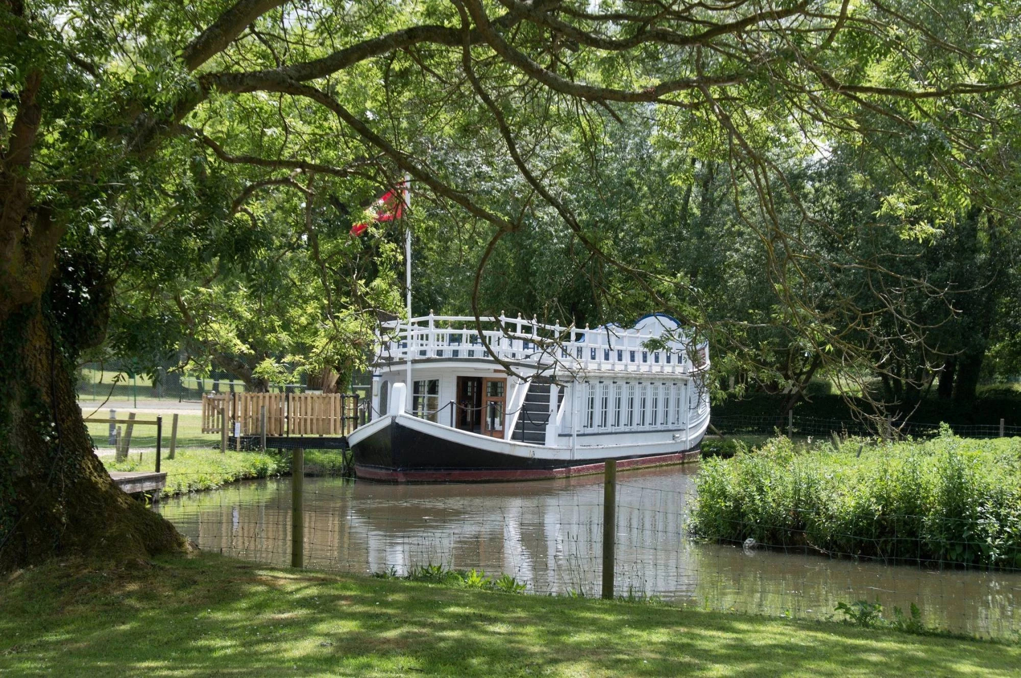 Historic riverboat moored beside the River Thames in the peaceful grounds of voco® Oxford Thames.