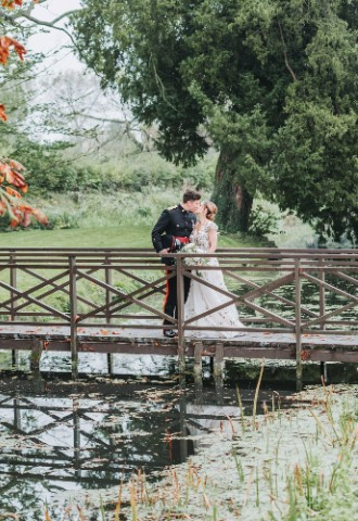 Bride and Groom kissing on the bridge of Ardington House