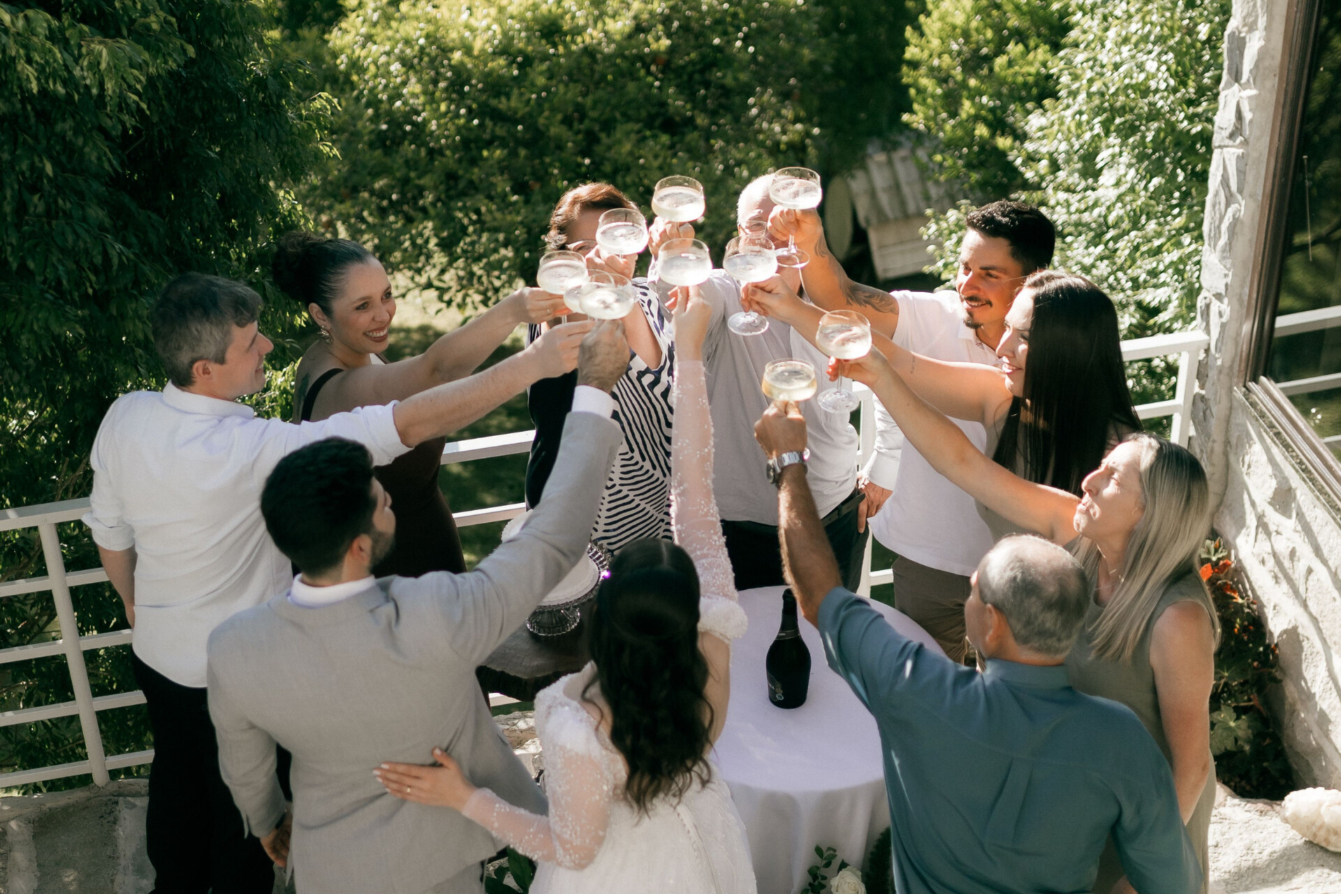Wedding guests raising a toast with the newly married couple during an outdoor drinks reception