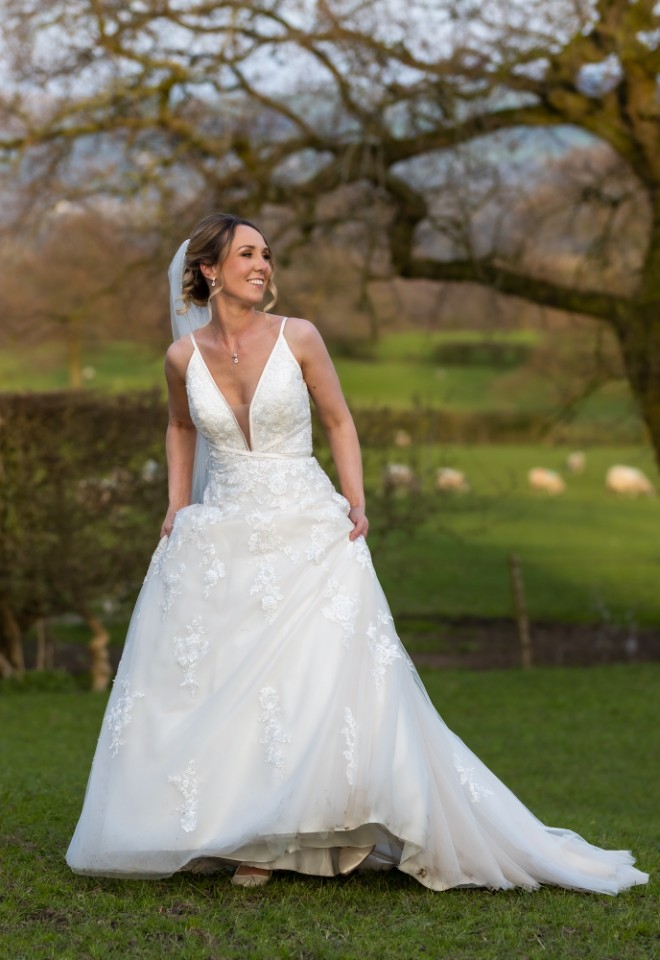 bride smiling stood in fields 