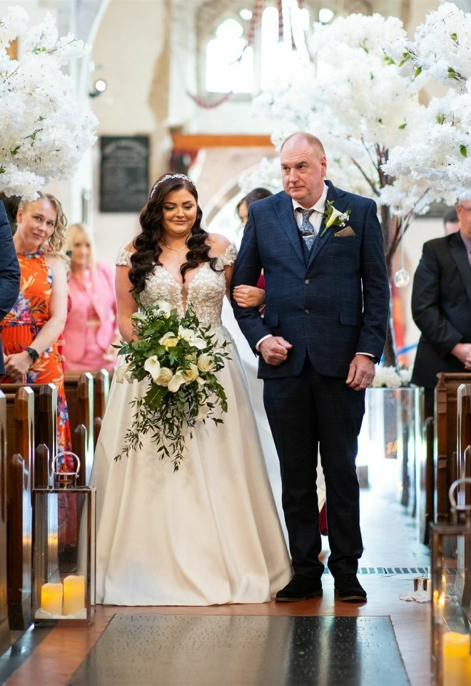 Bride being walked down the aisle with Father of the bride