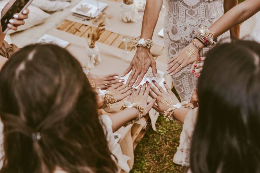 Ladies enjoying hen night with "team bride" written on hands