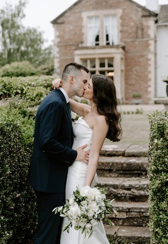 Bride and Groom kissing outside of Glewstone Court