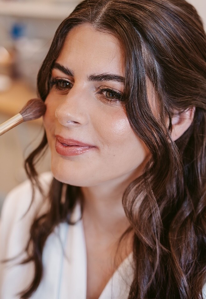 bride getting her makeup applied on her wedding day