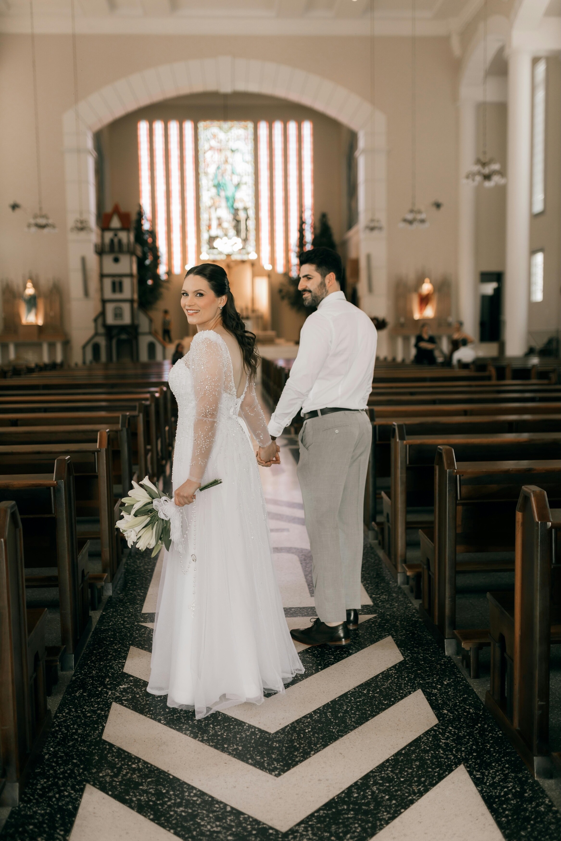 Bride and groom walk through a church together