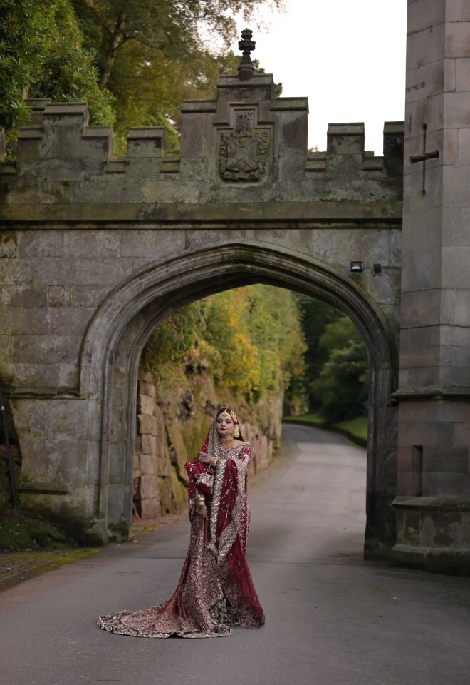 Bride posing under the arch of the castle
