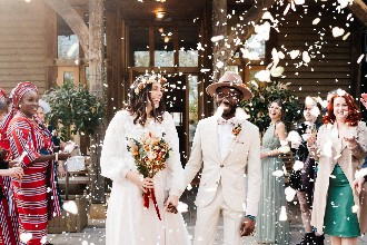 Wedding couple walking through confetti outdoors at The Oak Tree of Peover