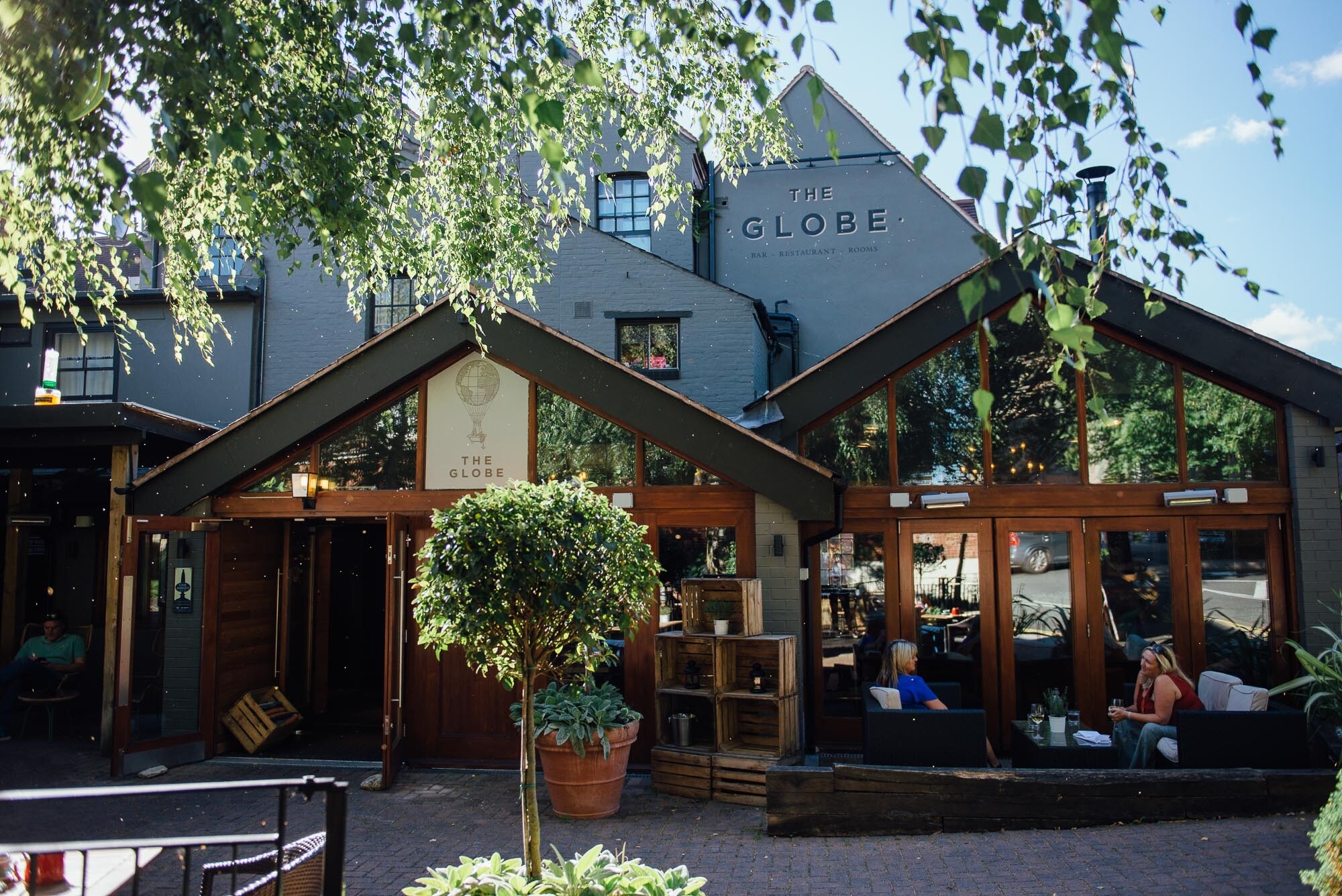 Exterior building of The Globe pub in Warwickshire, with outdoor seating out the front
