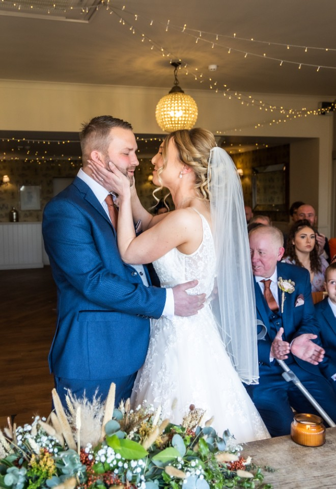 bride and groom at their ceremony, holding eachother