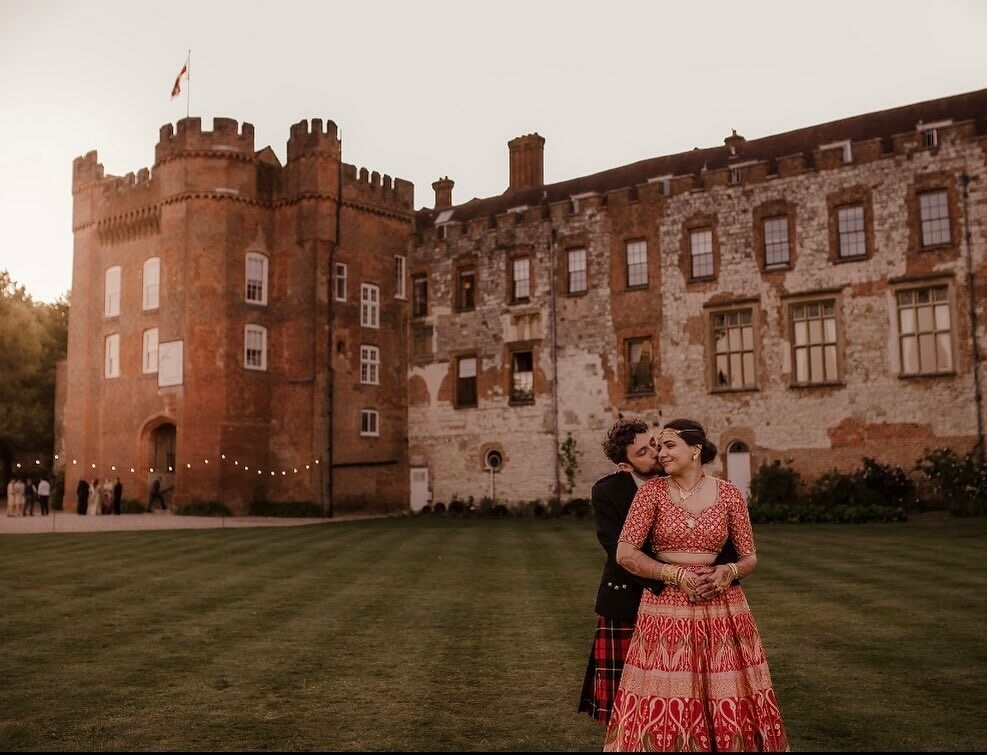 bride and groom in front of Farnham Castle