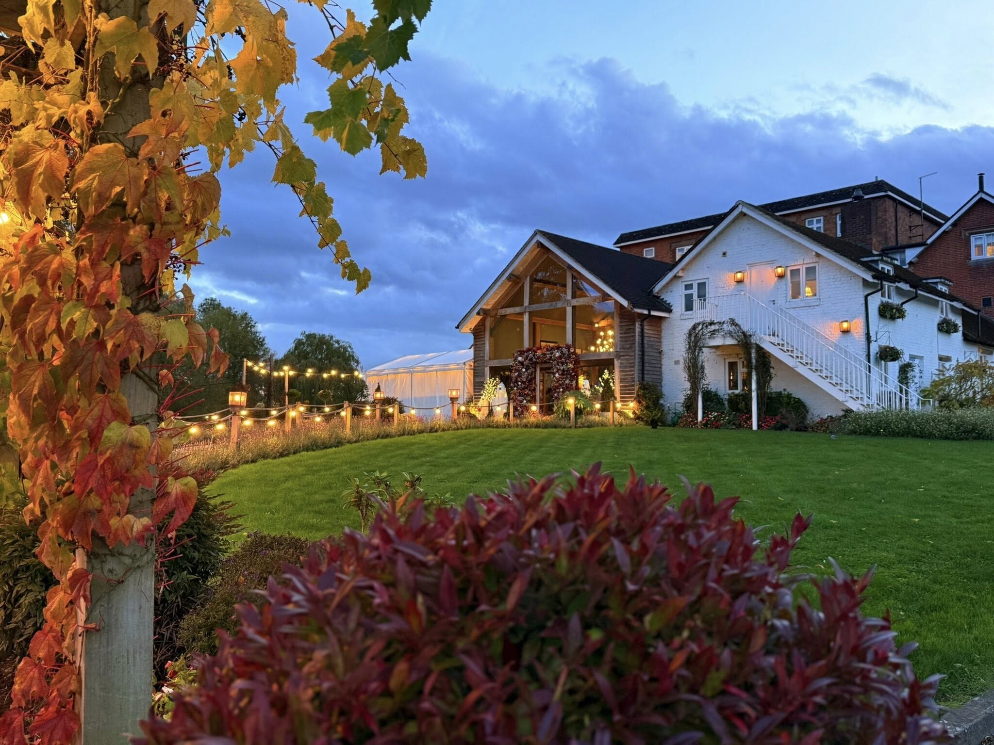 Exterior of the Arrow Mill pub in Warwickshire, with red and orange autumn leaves.
