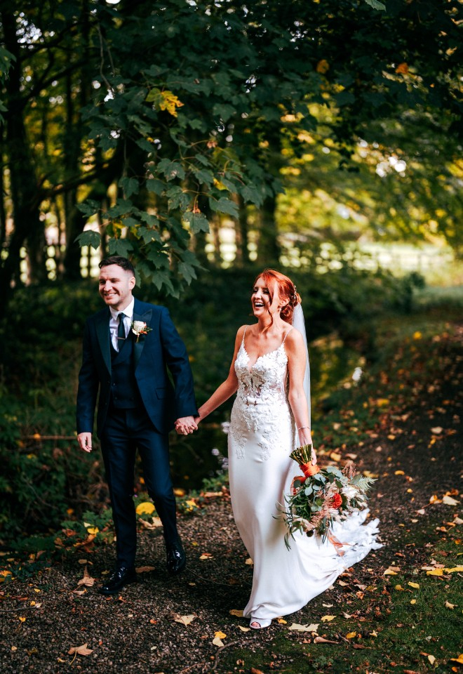 Bride and Groom walking through the woodland 