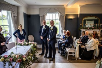 groom waiting at the end of the aisle with best man