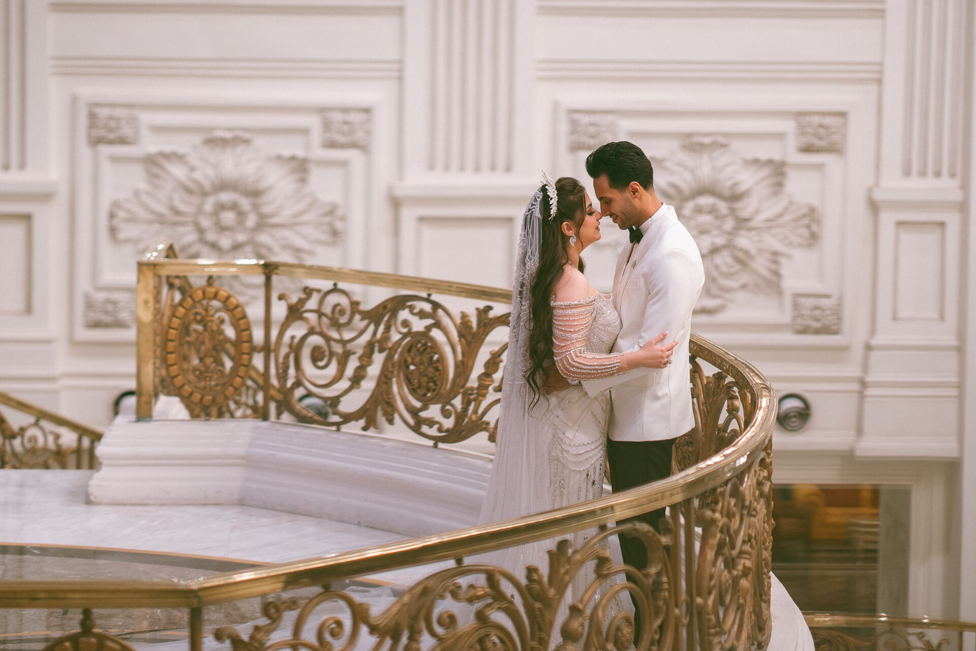 Newlyweds sharing a quiet moment in an elegant venue featuring grand architectural details.