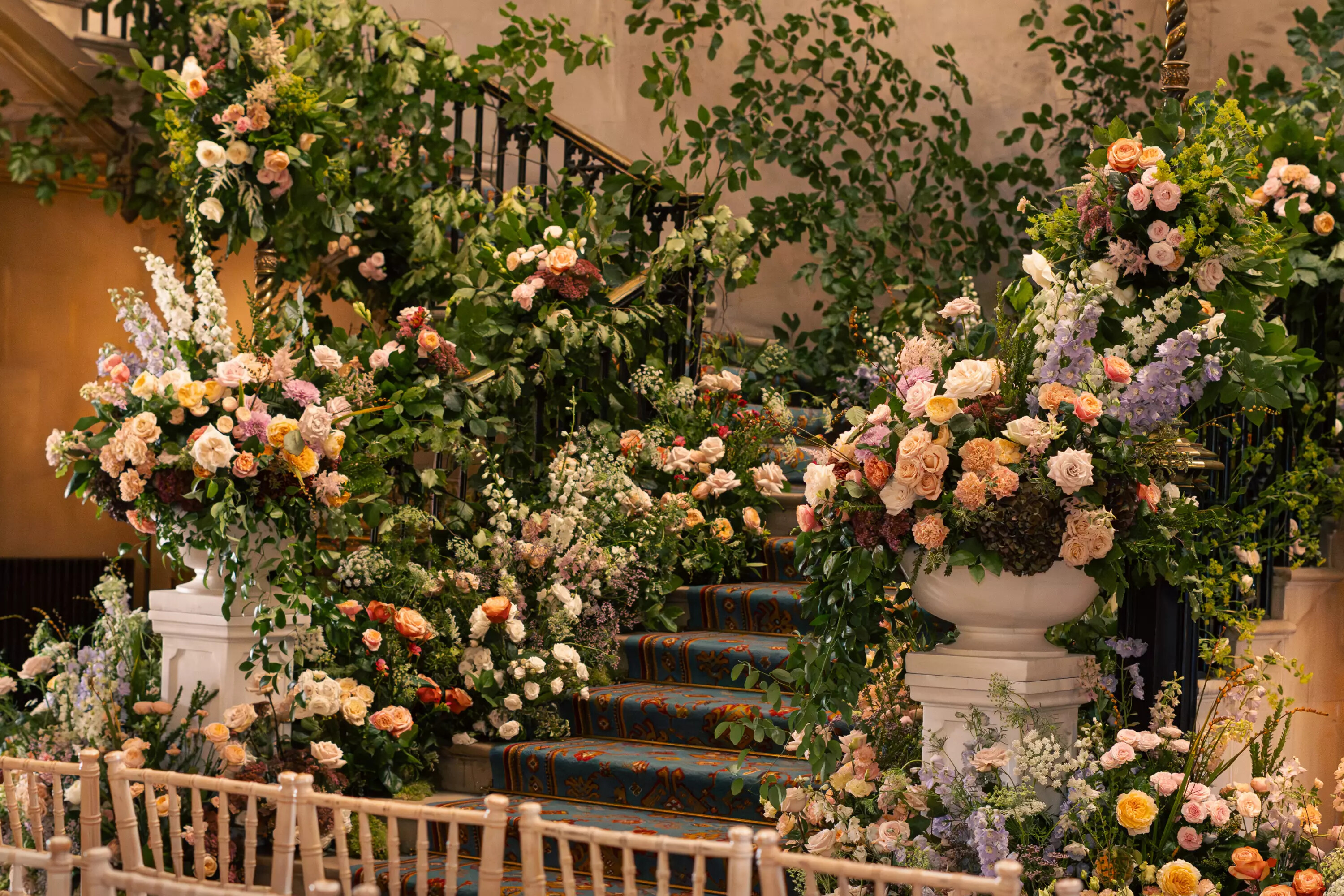 Colourful wedding ceremony floral arrangements positions on the staircase of a country house venue