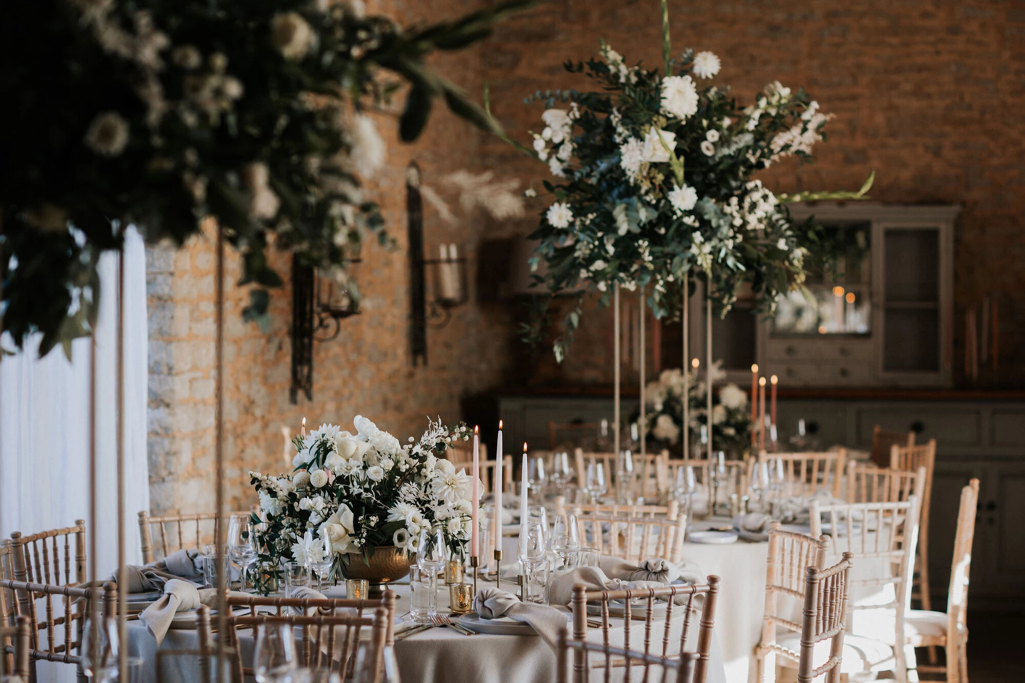Table arrangements of white wedding flowers by a professional florist