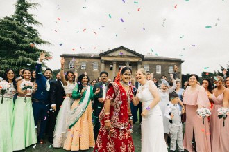 Brides and family celebrate in front of Rise Hall