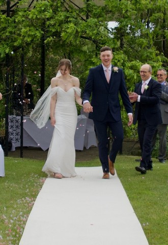Bride and groom leaving their outdoor wedding ceremony at East Sussex National