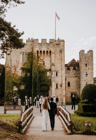 Bride and Groom walking in front of Hever Castle Wedding venue