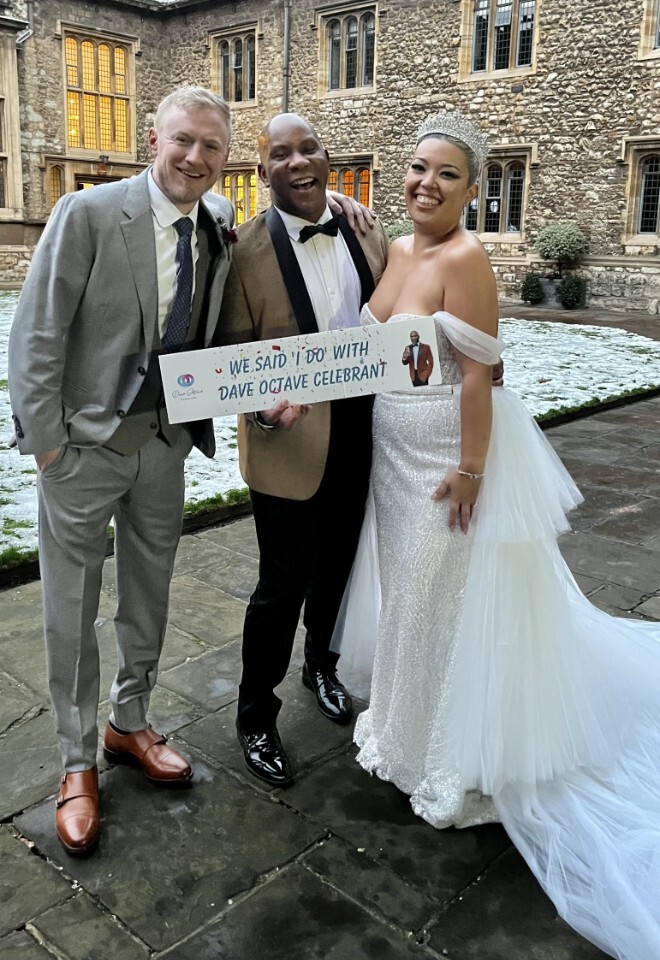 Dave Octave Celebrant with a happy bride and groom smiling and holding my We said I Do with Dave Octave Celebrant sign.