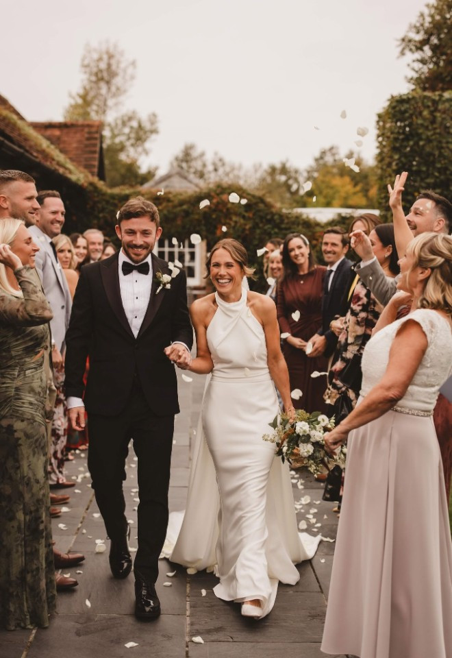 Bride & Groom just married, petals being thrown by wedding guests at Southend Barns Chichester, Sussex