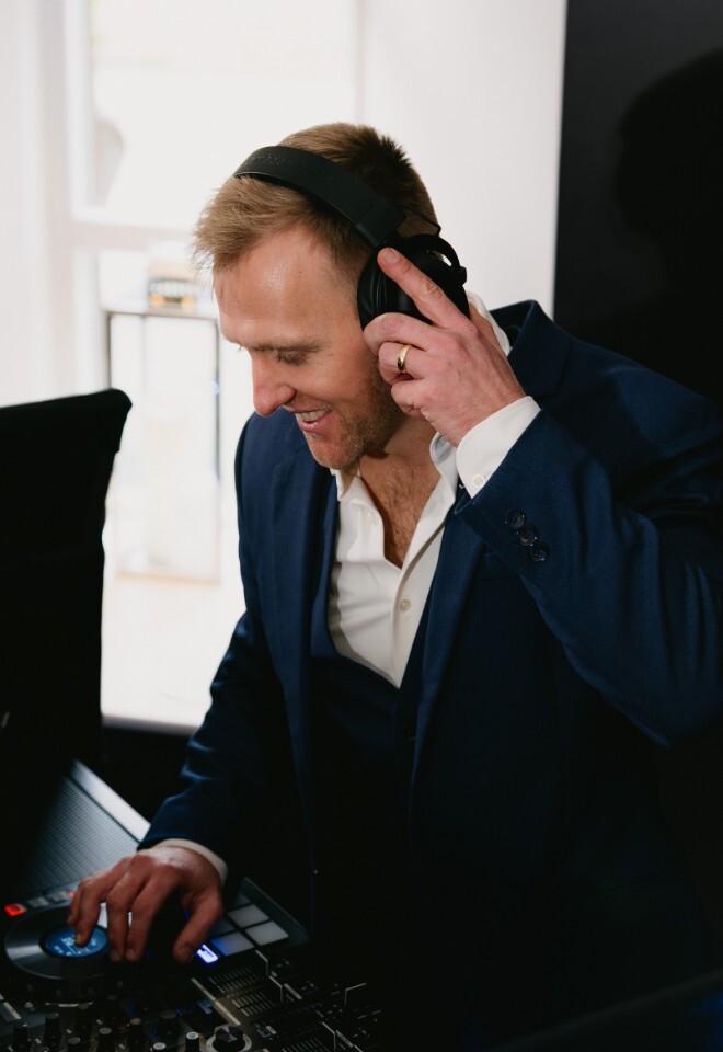 Matt Rayner, an Essex based DJ is wearing headphones while mixing on his controller