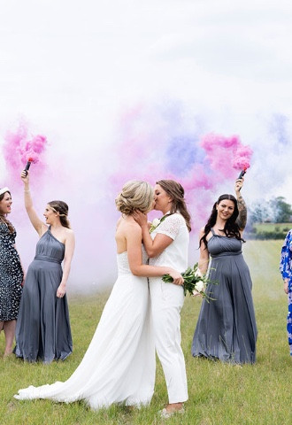 gay wedding with two brides and bridesmaids with smoke bombs