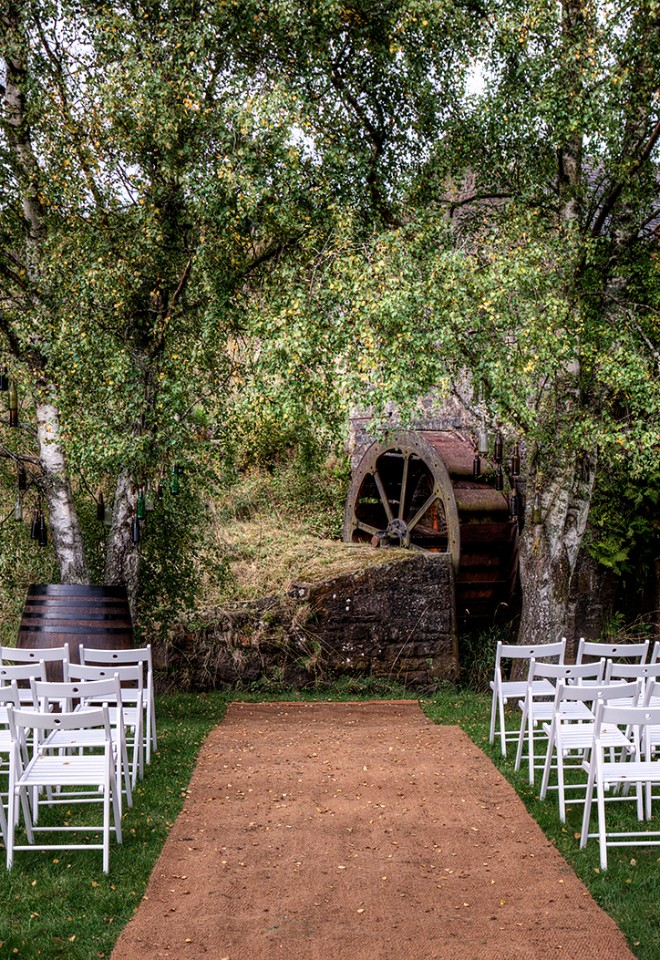 The water wheel framed by the Silver Birch trees in front of the ceremony area outside in the garden.