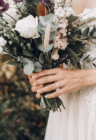 Bride holding bouquet featuring wedding ring with diamonds from Anelli Ltd