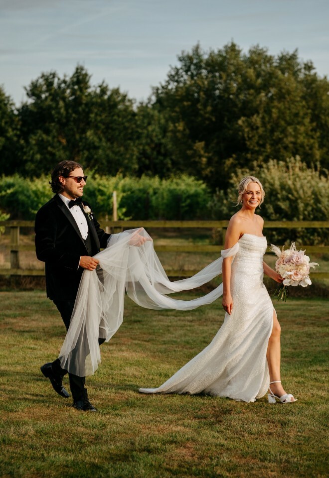 Bride and groom walking next to vineyard