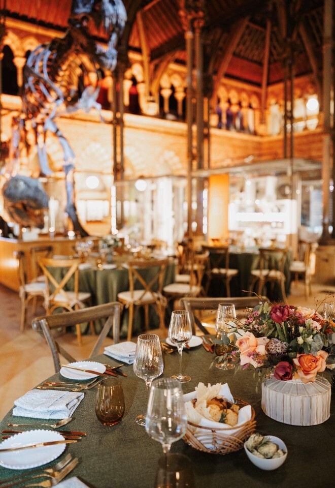 Round Table, Green Linen, Ripple Glassware, Gold Cutlery, Pearl Plates, Cross Back Chairs, in the Natural History Museum Oxford