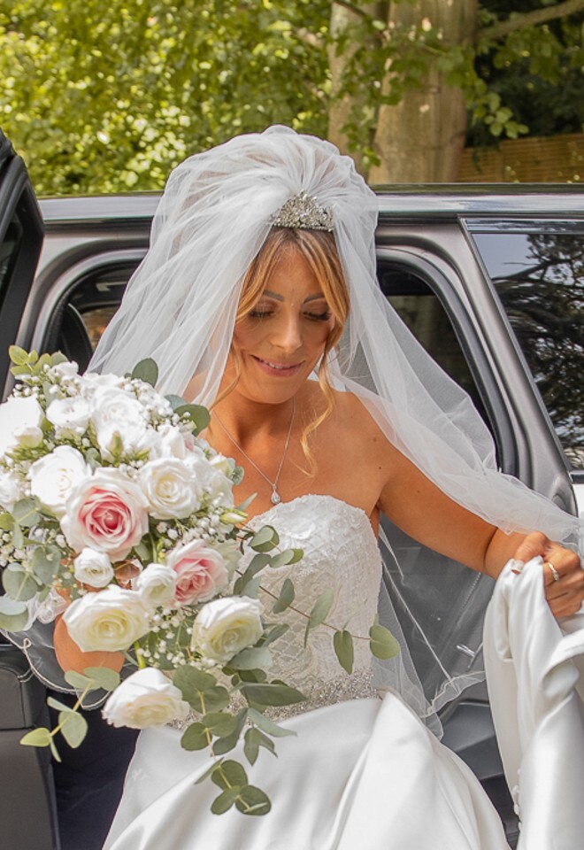 Bride stepping from car at Sonning Church Berkshire