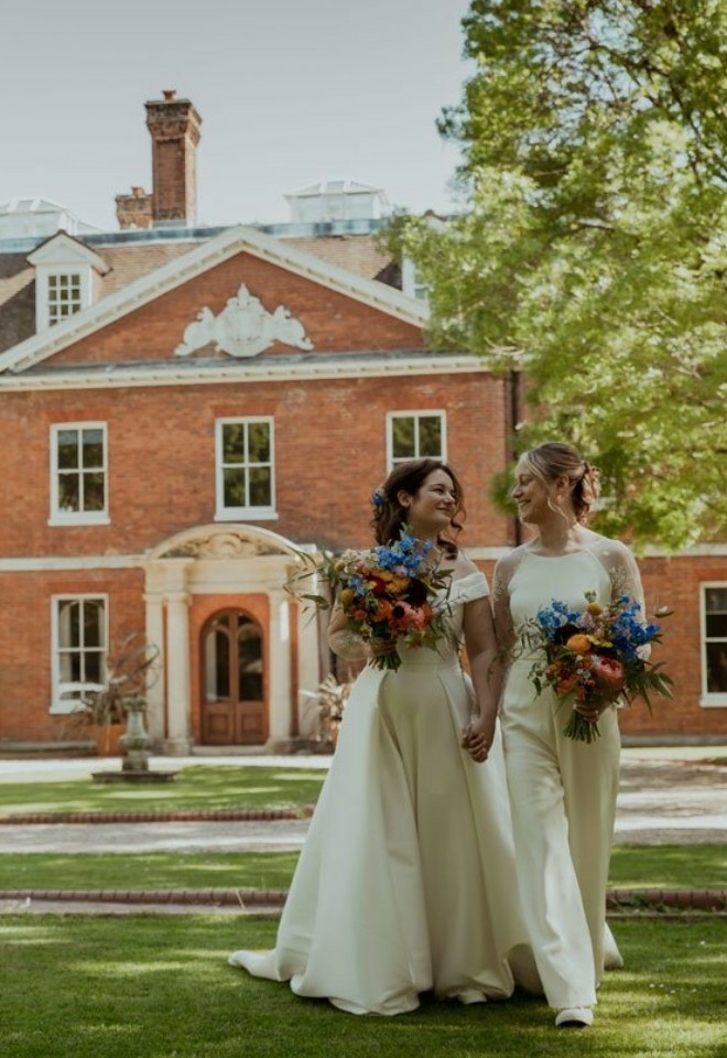 Brides in fromnt of Country House Wedding venue