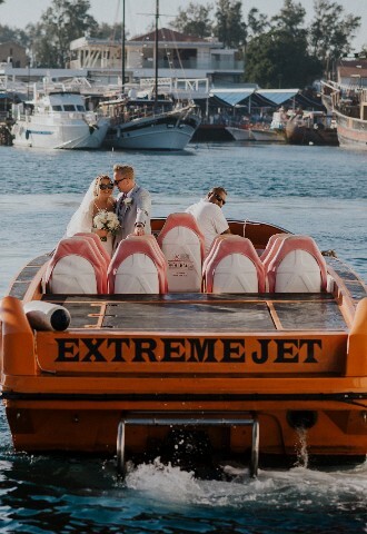 bride and groom leaving their wedding ceremony on a jet boat